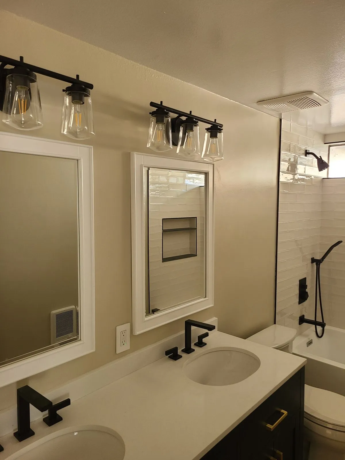 Modern renovated bathroom with black fixtures, subway tile, and new vanity