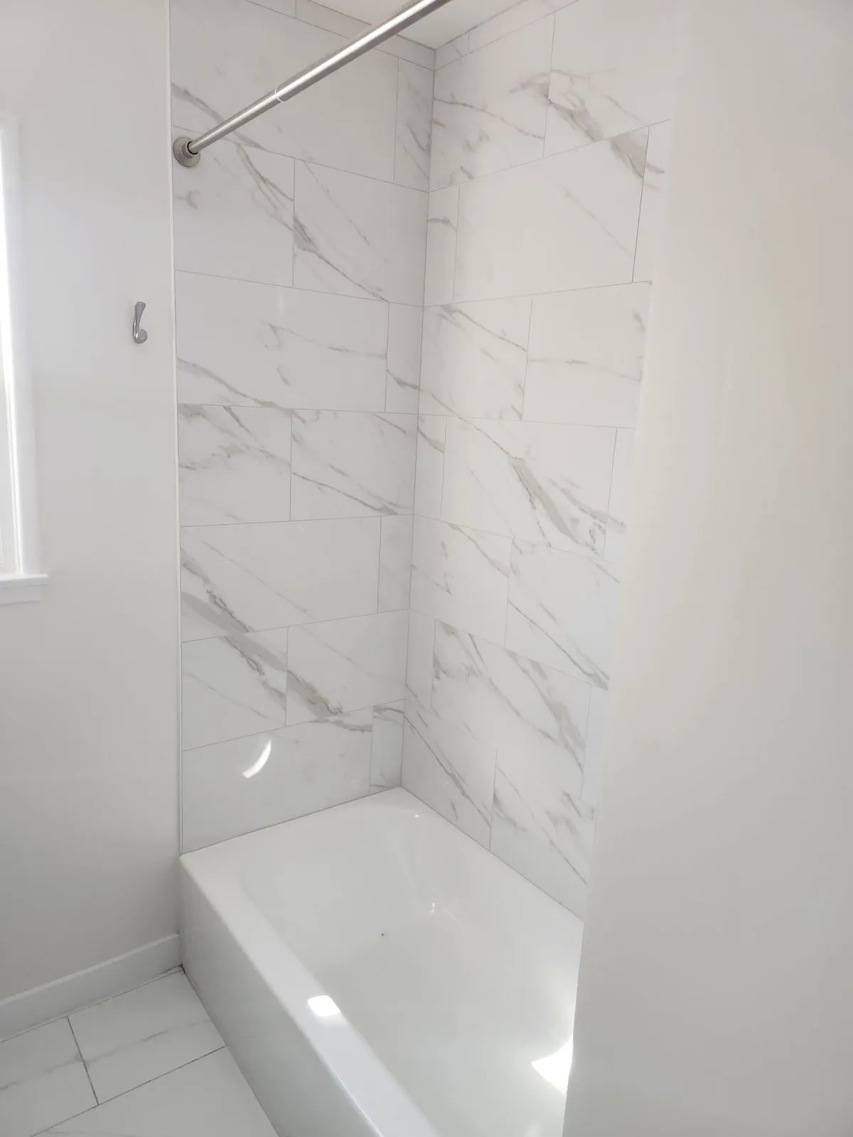 Bathtub surround with marble tile installation