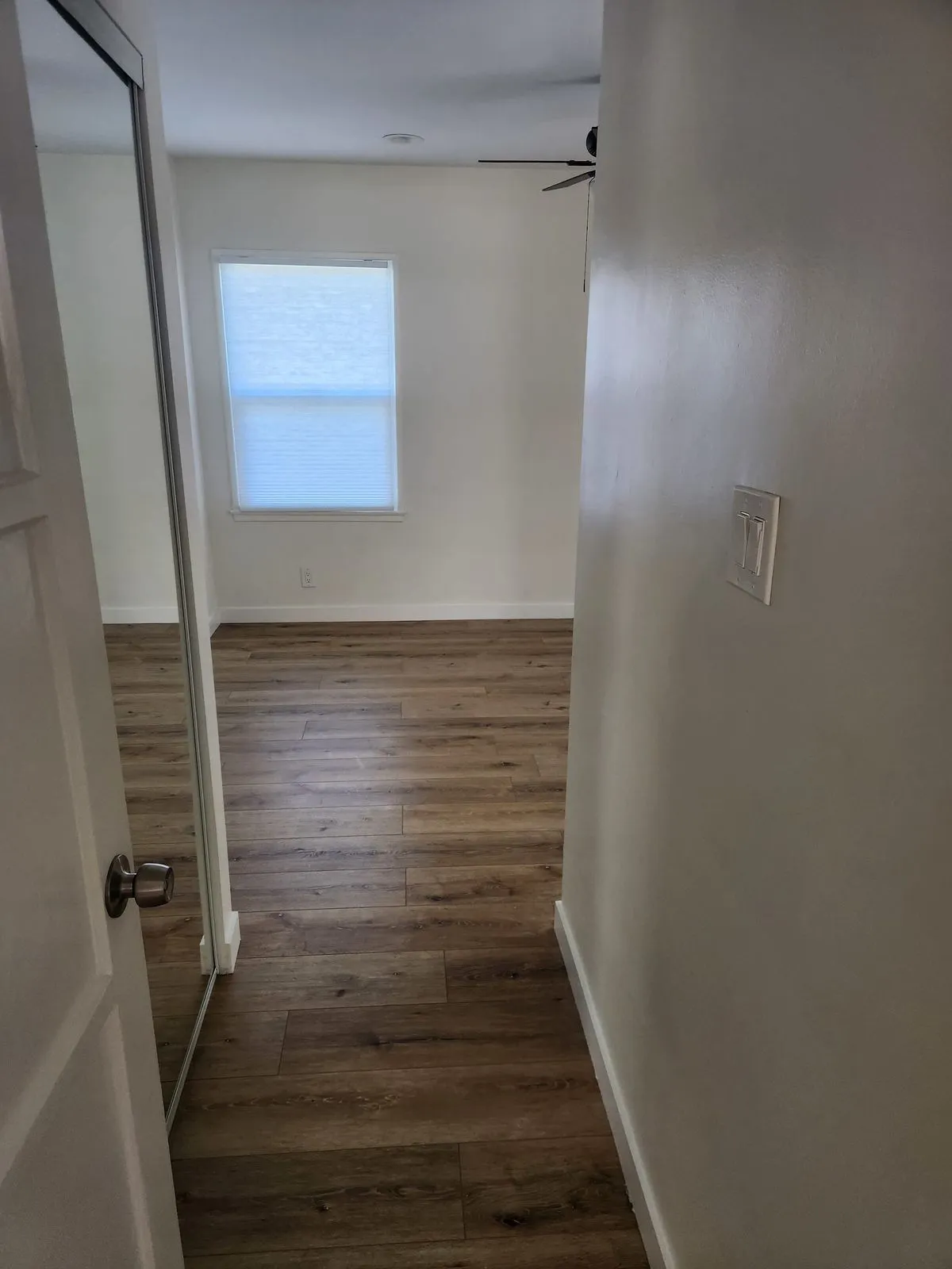 Bedroom with new flooring and mirrored closet doors