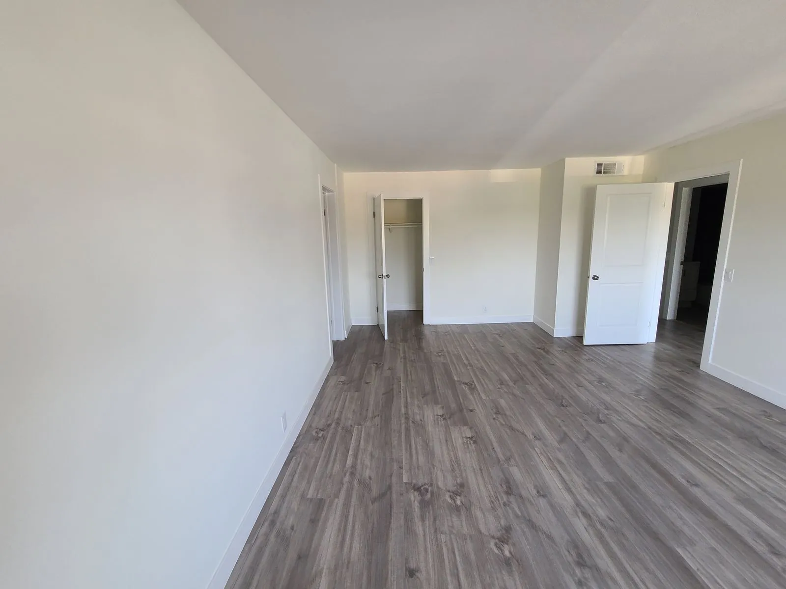 Bedroom with new flooring, closet, and doorways