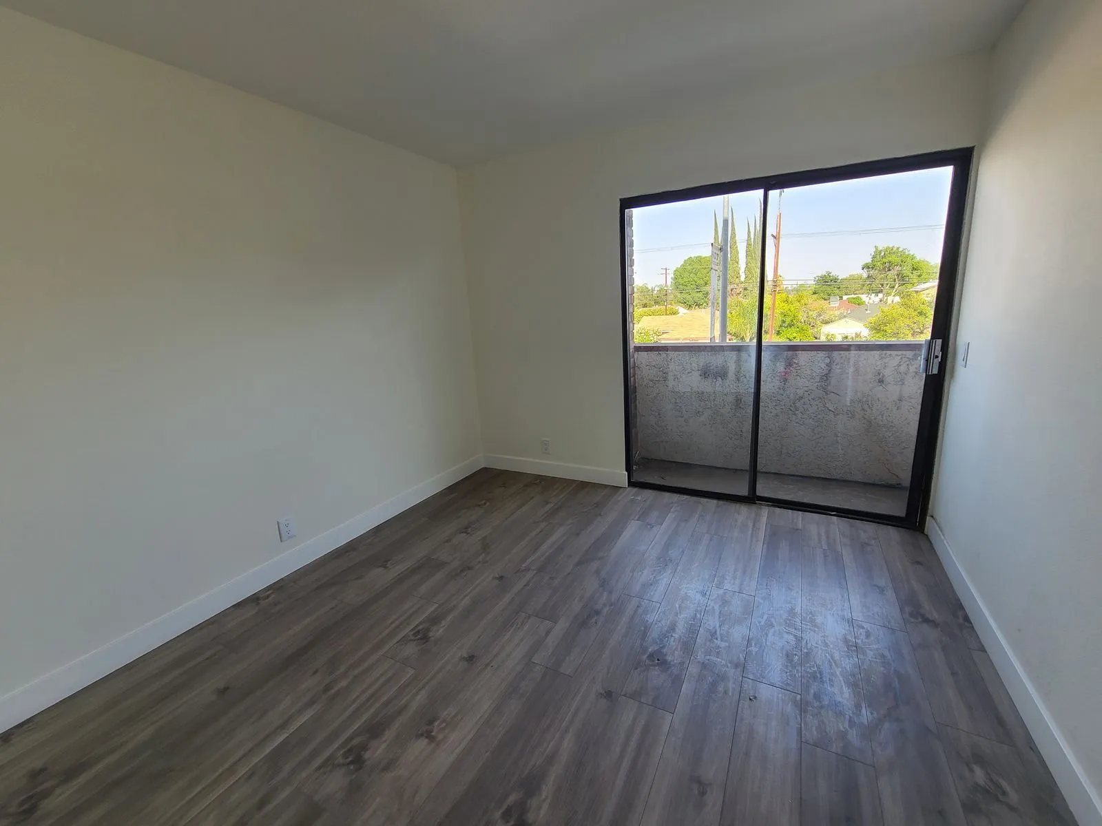 Bedroom with new vinyl plank flooring and sliding glass door