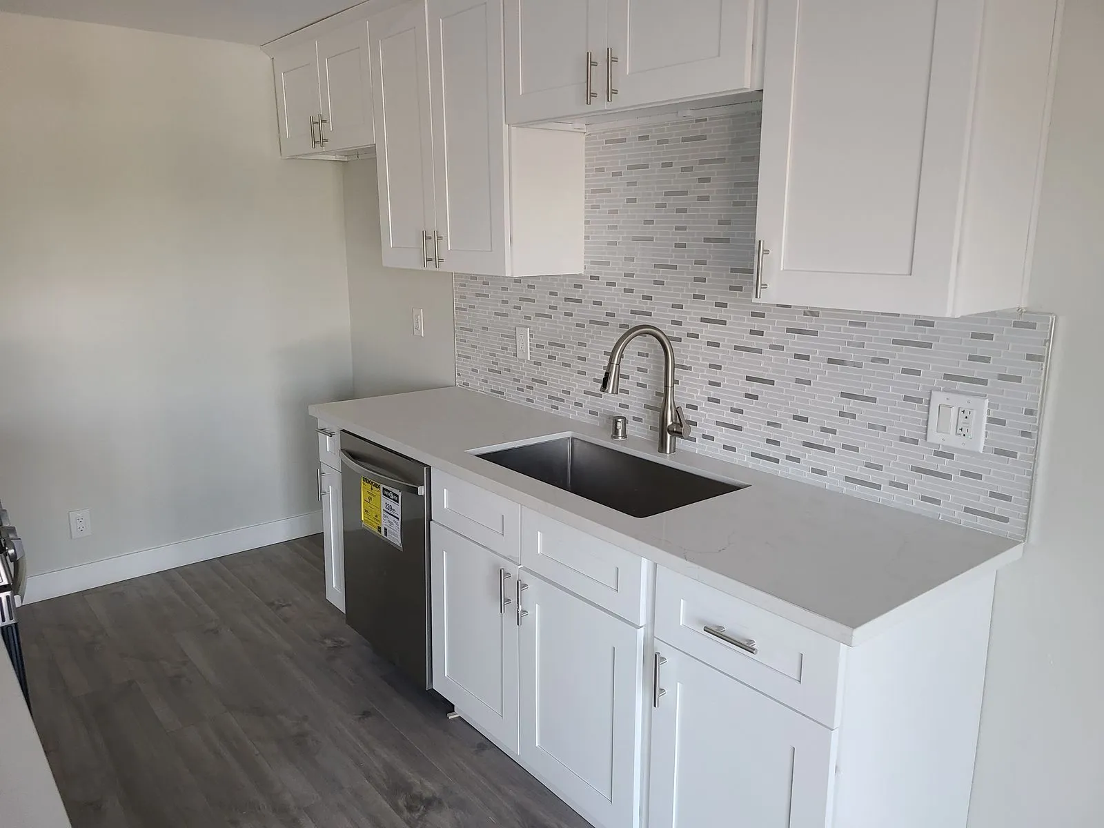 Kitchen remodel with white shaker cabinets and mosaic backsplash