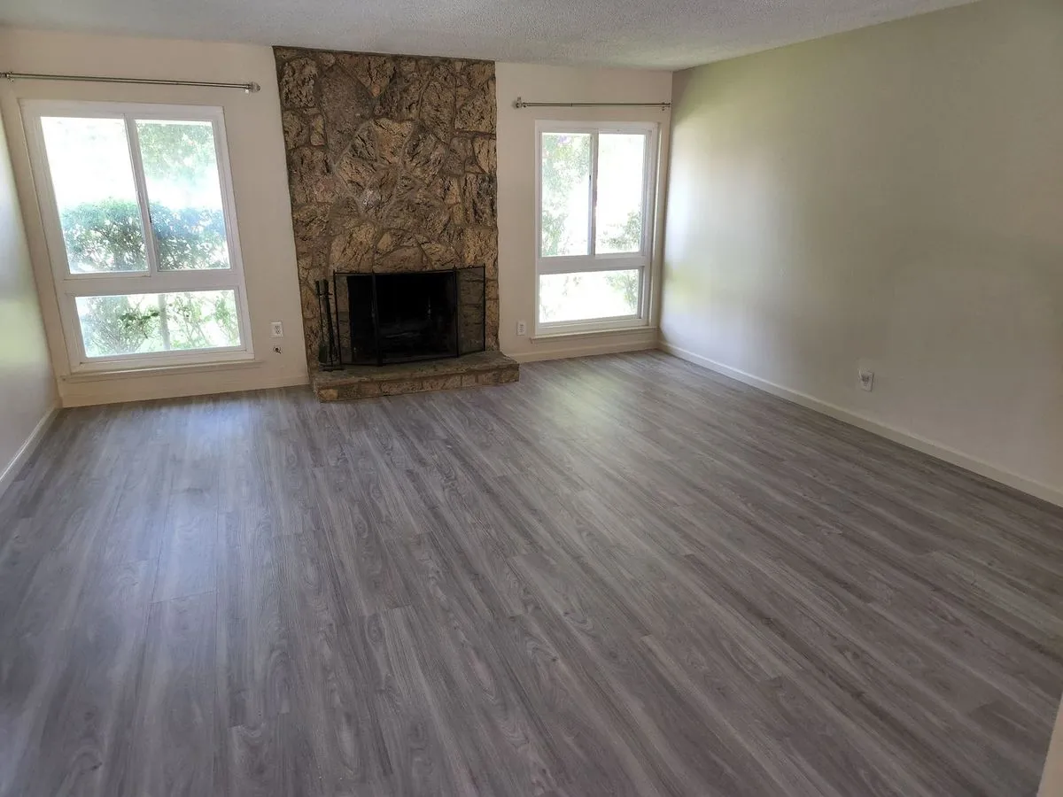 Living room with new flooring and stone fireplace